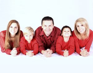 Familie liegend nach vorne mit roten Kleidern